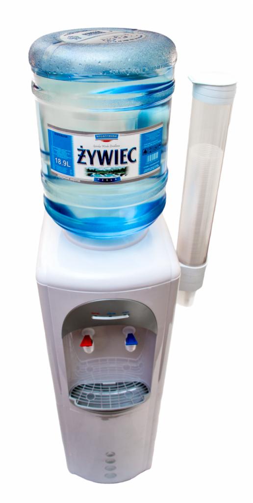 Dystrybutor wody z butlą 18.9L marki Żywiec, z dozownikiem na kubki, na białym tle.