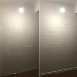 Porównanie ściany przed i po ułożeniu białych, poziomych paneli boazeryjnych; po lewej ściana z widocznymi plamami i ubytkami, po prawej wykończona panelami, oświetlona żarówką.