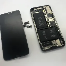 Rozłożony smartfon z widocznym ekranem i wnętrzem, bateria Li-ion, Taptic Engine, na białym tle.