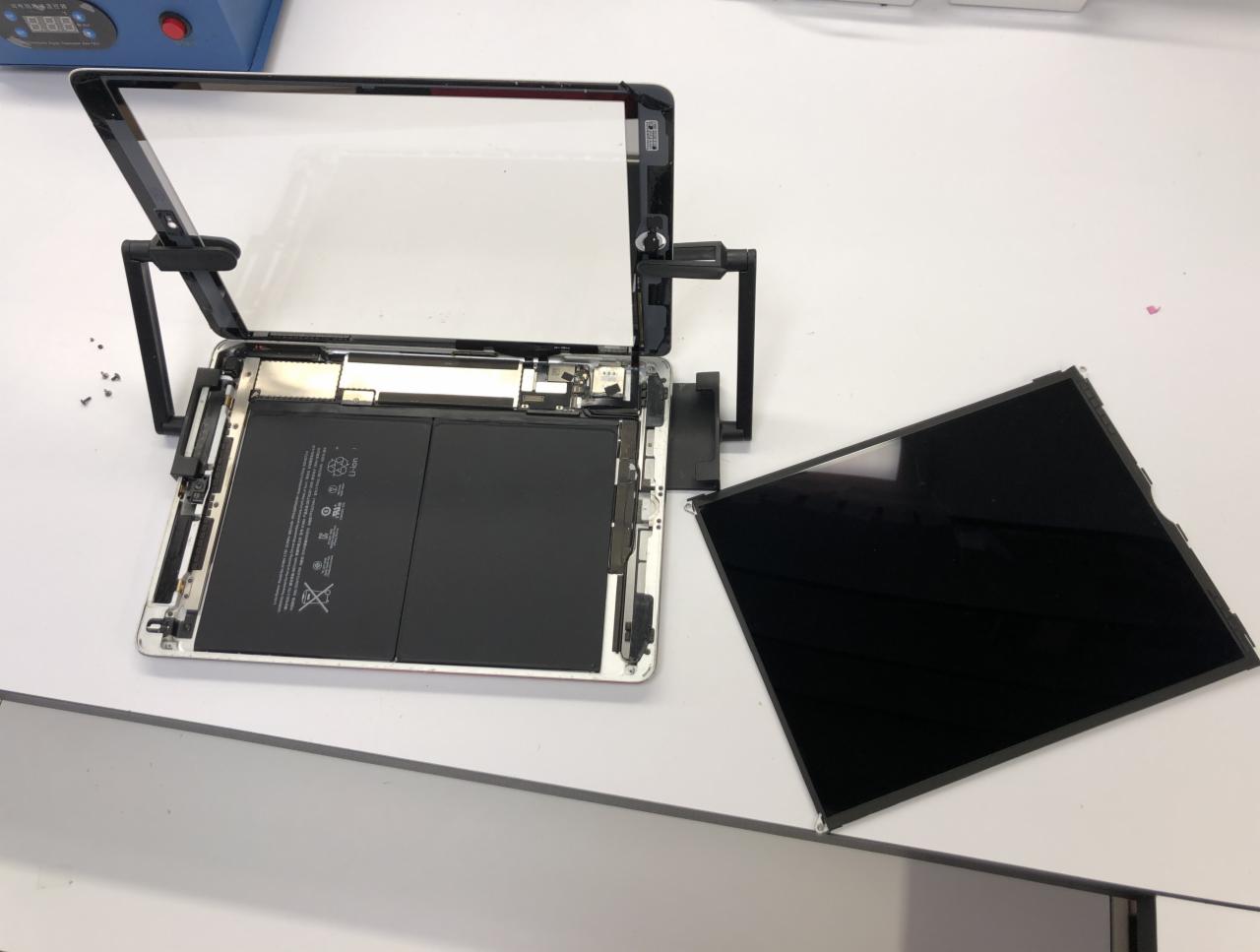 Rozłożony tablet z odseparowanym ekranem w warsztacie w Rzeszowie, widoczna bateria i wewnętrzne komponenty.