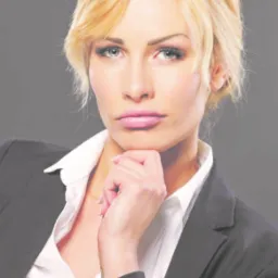 Portret kobiety w czarnym żakiecie i białej koszuli, dłoń pod brodą, profesjonalny wizerunek.