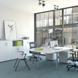 Jasne biuro z białymi meblami: szafki z frontami bez uchwytów, biurko z szufladami i krzesła biurowe na tle dużego okna z widokiem na zieleń.