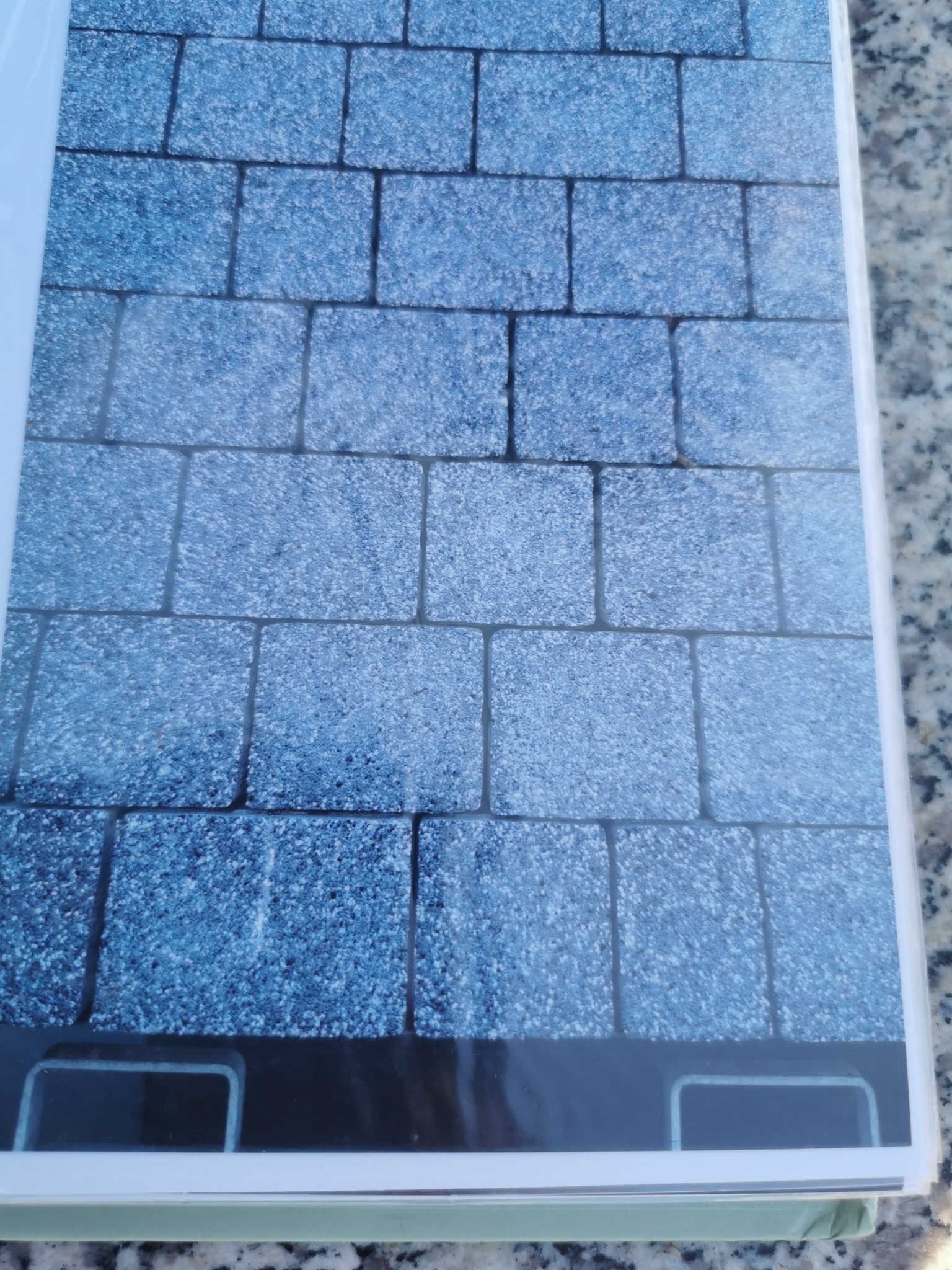 Szlifowany, niebieski kamień w kształcie kostki brukowej, układany w rzędach, widoczny w katalogu z bliska, z detalami faktury.