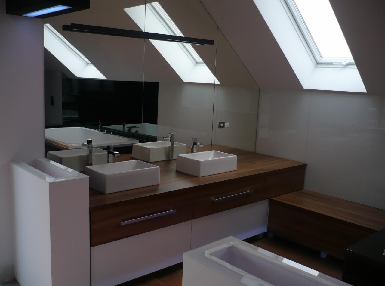 Nowoczesna łazienka na poddaszu w Jadownikach z dwoma prostokątnymi umywalkami nablatowymi, drewnianym blatem i lustrem na całą ścianę odbijającym wannę oraz okna dachowe.
