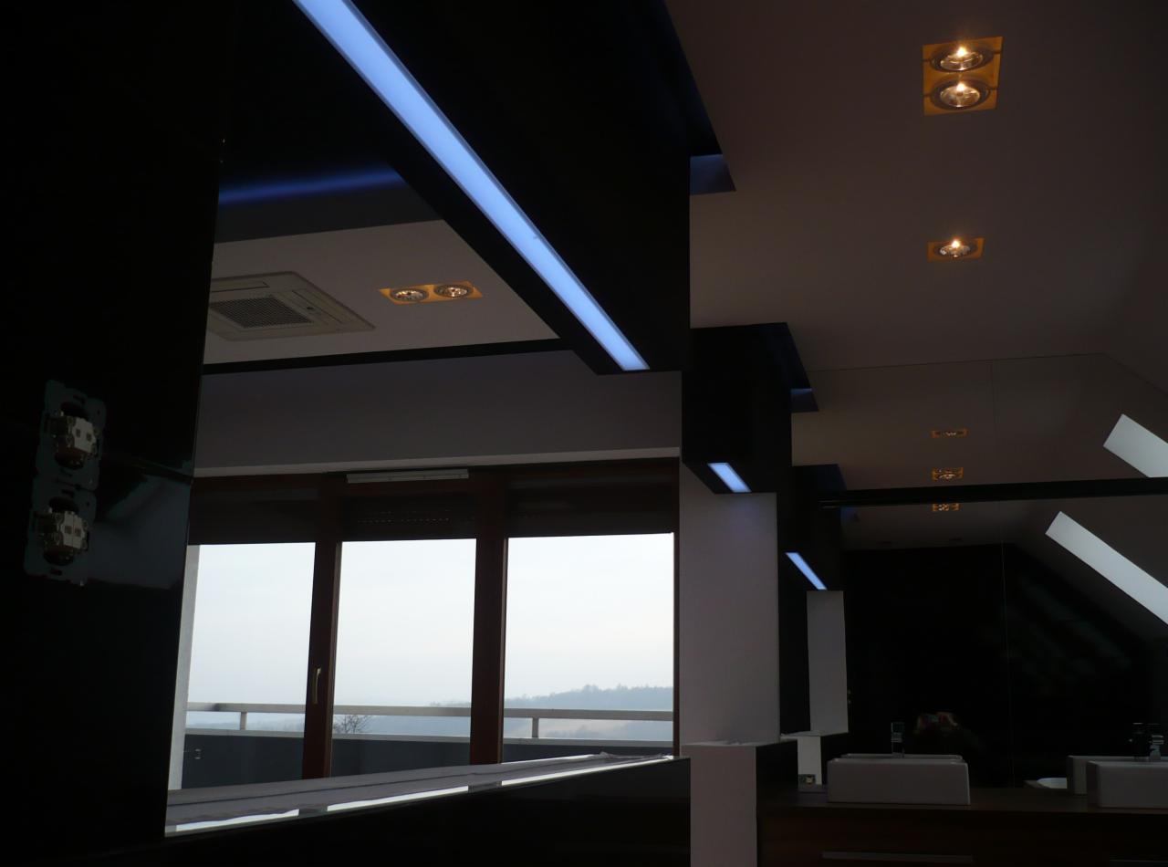 Nowoczesna łazienka z czarnymi elementami i oświetleniem LED, widok na okno z widokiem na krajobraz.