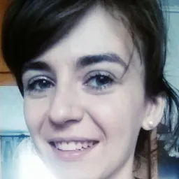 Portret uśmiechniętej młodej kobiety z krótkimi ciemnymi włosami i jasnymi oczami, noszącej perłowy kolczyk.