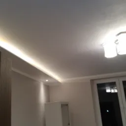 Nowoczesne oświetlenie sufitowe z listwą LED i lampą wiszącą w nowym wnętrzu.