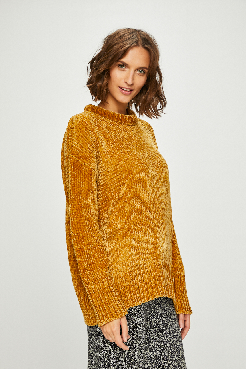 Portret kobiety w musztardowym, pluszowym swetrze z golfem, na białym tle.