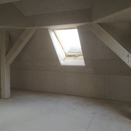 SUPRA PRZEDSIĘBIORSTWO BUDOWLANE - Poddasze z oknem dachowym, ściany wyłożone płytami gipsowo-kartonowymi na konstrukcji wsporczej, widoczne ślady po szpachlowaniu.