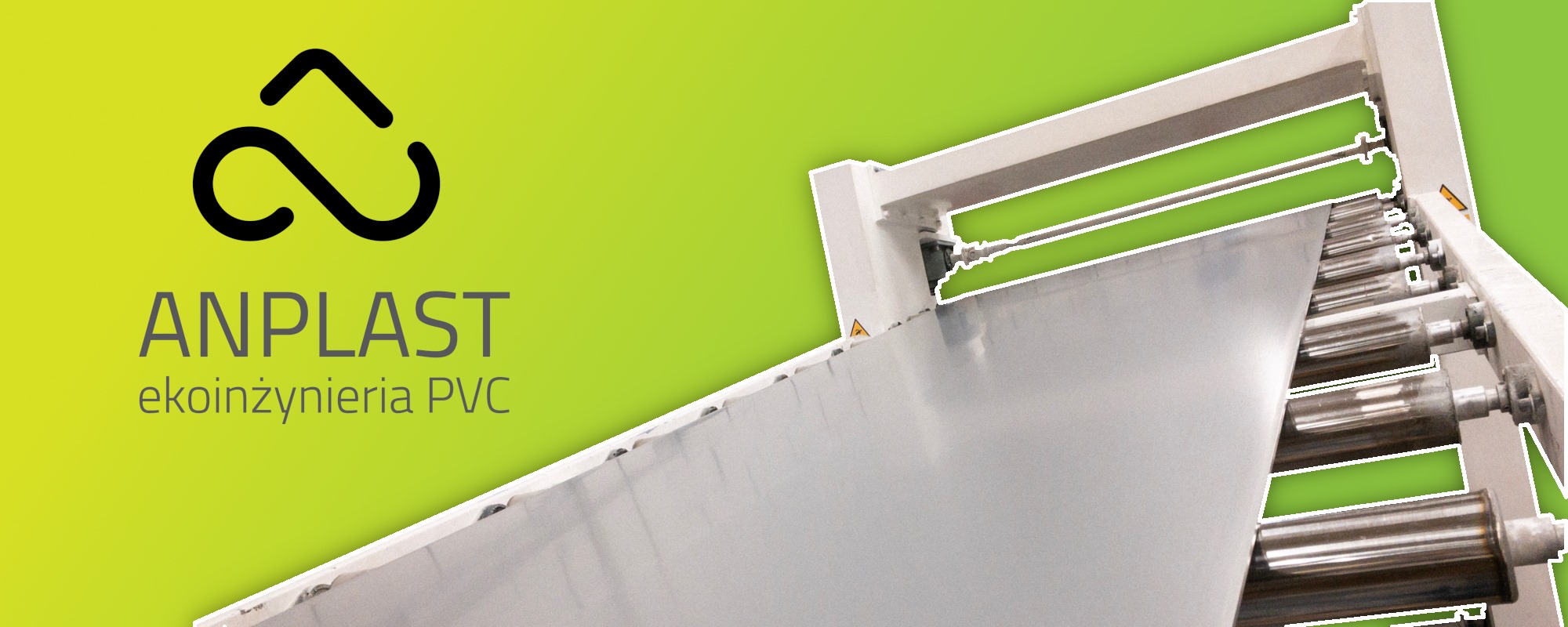 Logo firmy Anplast EkoInżynieria PVC na tle linii produkcyjnej z walcami do obróbki tworzyw sztucznych.