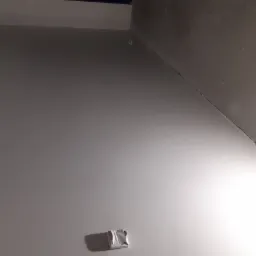 Fragment wnętrza w trakcie prac wykończeniowych, widoczna świeżo pomalowana ściana z wystającymi kablami elektrycznymi i zabezpieczonym gniazdkiem, surowy strop, przygotowywane do dalszych prac.