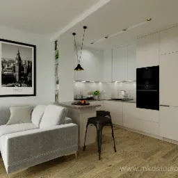 Wnętrze mieszkania w neutralnych barwach: szara sofa z poduszką, plakat Londynu na ścianie, aneks kuchenny z białymi szafkami i czarnym piekarnikiem, drewniana podłoga i dwa metalowe stołki barowe.