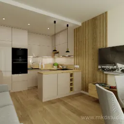 Beżowa kuchnia z drewnianymi akcentami: zabudowa kuchenna z błyszczącymi frontami, czarny piekarnik, drewniany blat, pionowe drewniane panele na ścianie obok telewizora z czarno-białym obrazem...