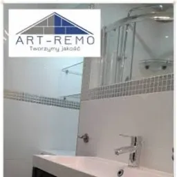 Nowoczesna łazienka z kabiną prysznicową, umywalką nablatową i lustrem z dekoracyjną mozaiką. Widoczne logo firmy ART-REMO. Tworzymy jakość.