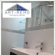 Nowoczesna łazienka z kabiną prysznicową, umywalką nablatową i lustrem z dekoracyjną mozaiką. Widoczne logo firmy ART-REMO. Tworzymy jakość.