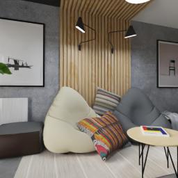 Aga Gromak - Studio Projektowe - Wizualizacja pokoju dziennego z pufami w kształcie worków, stolikami kawowymi z czarnymi nogami, drewnianą ścianą z oświetleniem punktowym i obrazami w czarnych ramach na szarej ścianie.