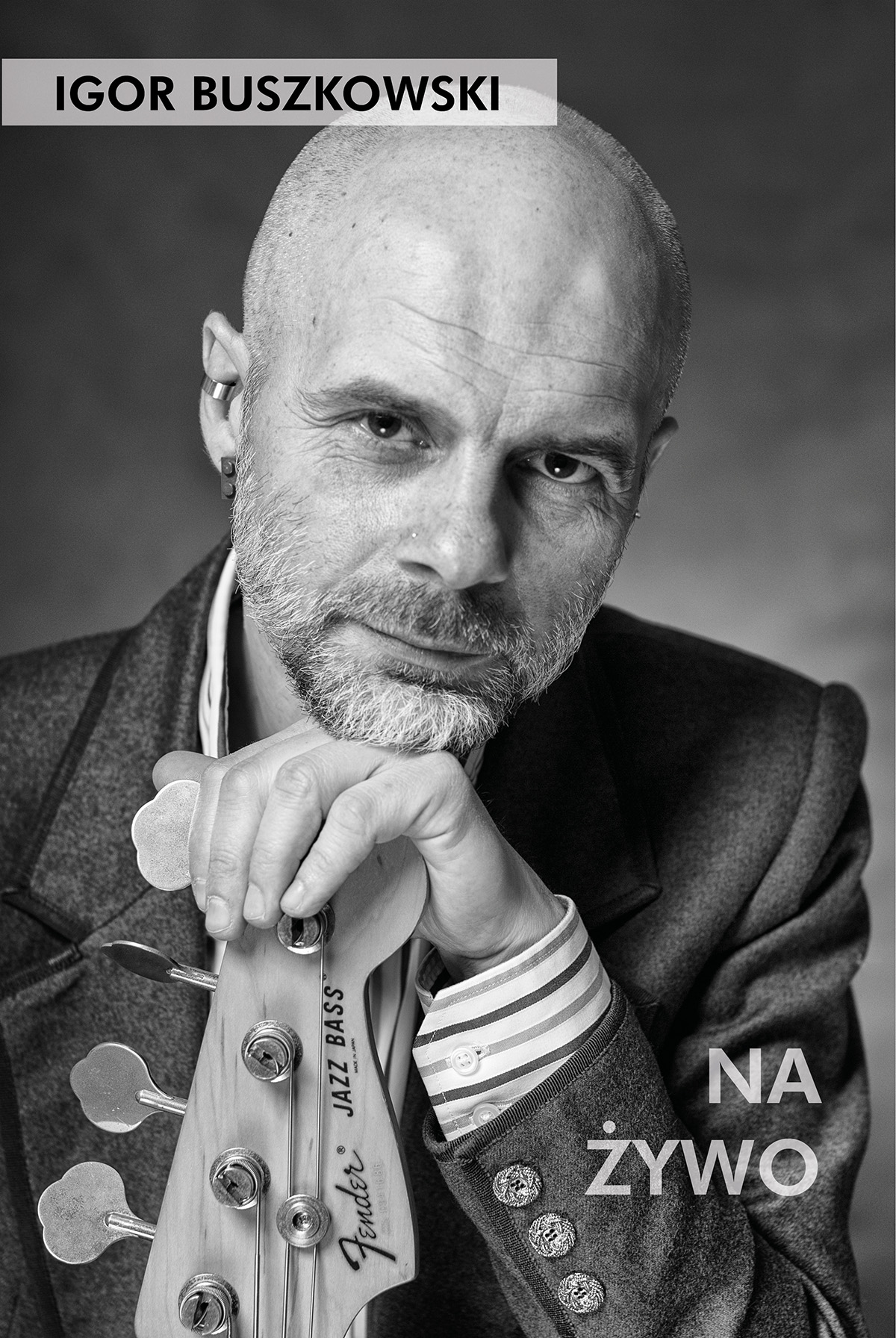 Czarno-biały portret muzyka z brodą, opierającego głowę na gryfie gitary basowej Fender Jazz Bass, w marynarce z ozdobnymi guzikami i koszuli w paski, z napisem 'NA ŻYWO'.