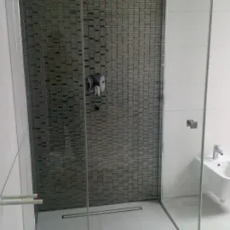 Nowoczesna kabina prysznicowa walk-in z deszczownicą i mozaiką na ścianie w łazience w Koszalinie, widoczny odpływ liniowy i biała armatura.