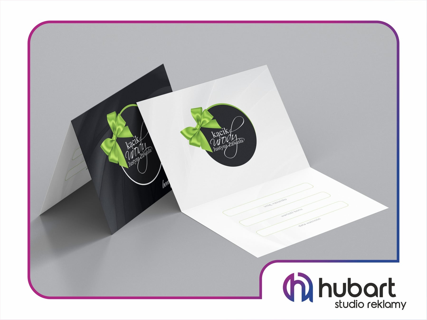 Otwarty, dwuczęściowy bon upominkowy w dwóch wersjach kolorystycznych: czarnej i białej, z minimalistycznym logo i zieloną wstążką, leżący na gładkim, szarym tle.