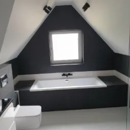 Nowoczesna łazienka na poddaszu z wanną w zabudowie, czarnymi ścianami i białymi płytkami podłogowymi, oświetlona światłem z okna dachowego i reflektorów.