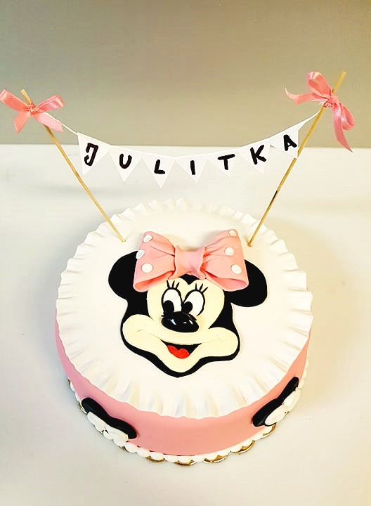 Tort okrągły z różowym lukrem i dekoracją Myszki Minnie z lukru, ozdobiony banerem z imieniem 'Julitka' i różowymi kokardkami.