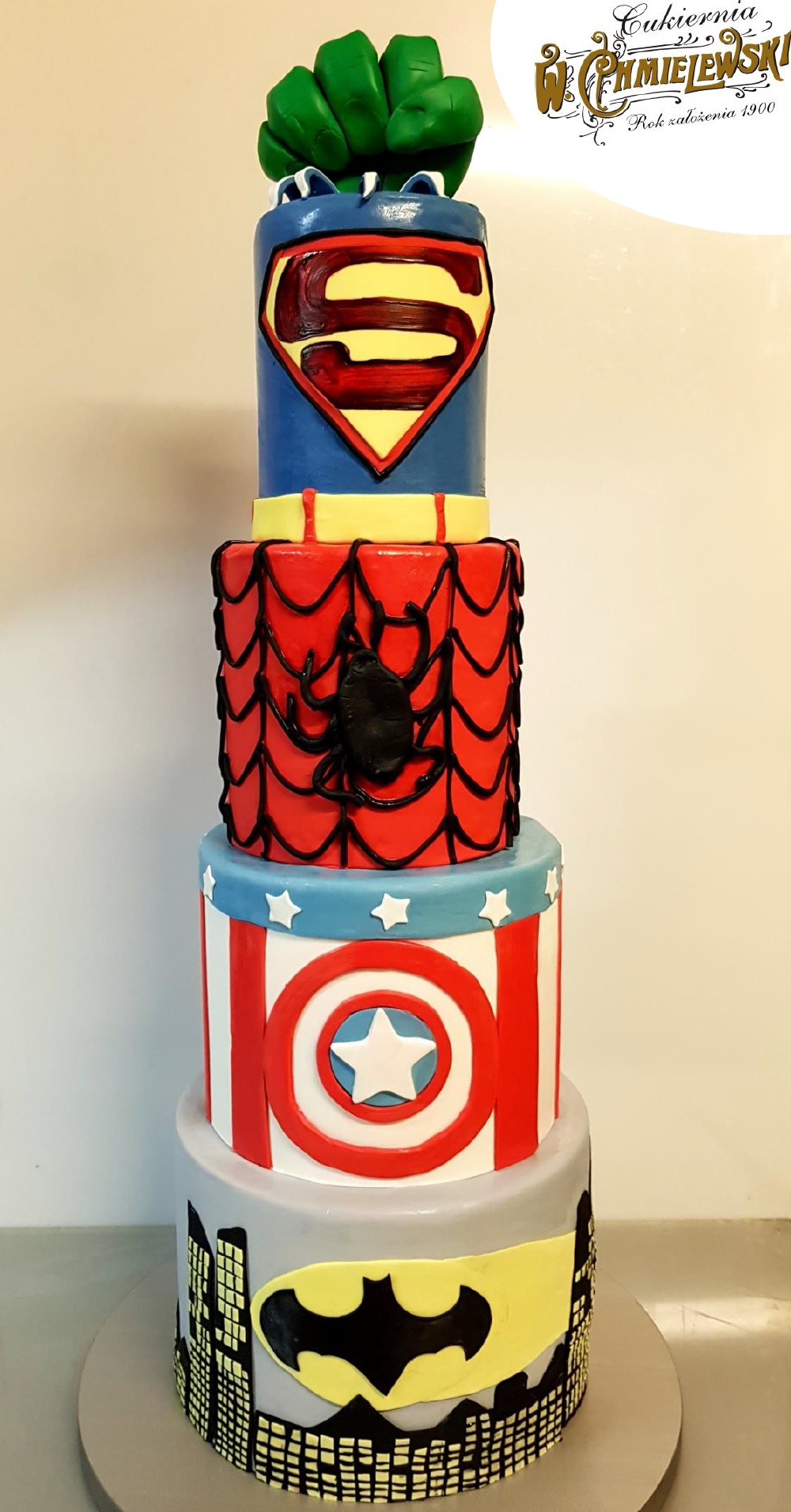 Wielopoziomowy tort urodzinowy z motywami superbohaterów: Hulk, Superman, Spider-Man, Kapitan Ameryka i Batman.