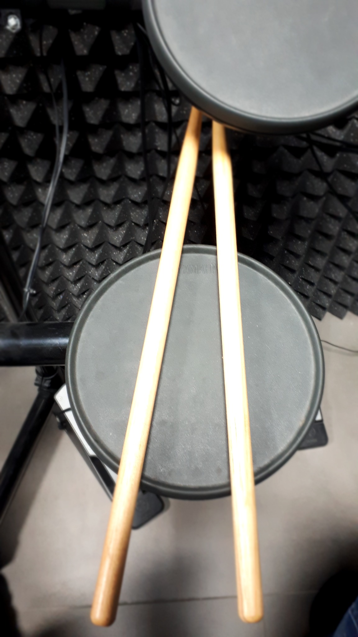 Pady perkusyjne Yamaha z pałeczkami na tle akustycznej pianki wygłuszającej.