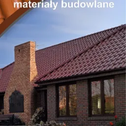Dom jednorodzinny z czerwonym dachem z dachówki ceramicznej, ceglaną elewacją i kominem, prezentowany z logo firmy 'LOSKO materiały budowlane' na górze zdjęcia.