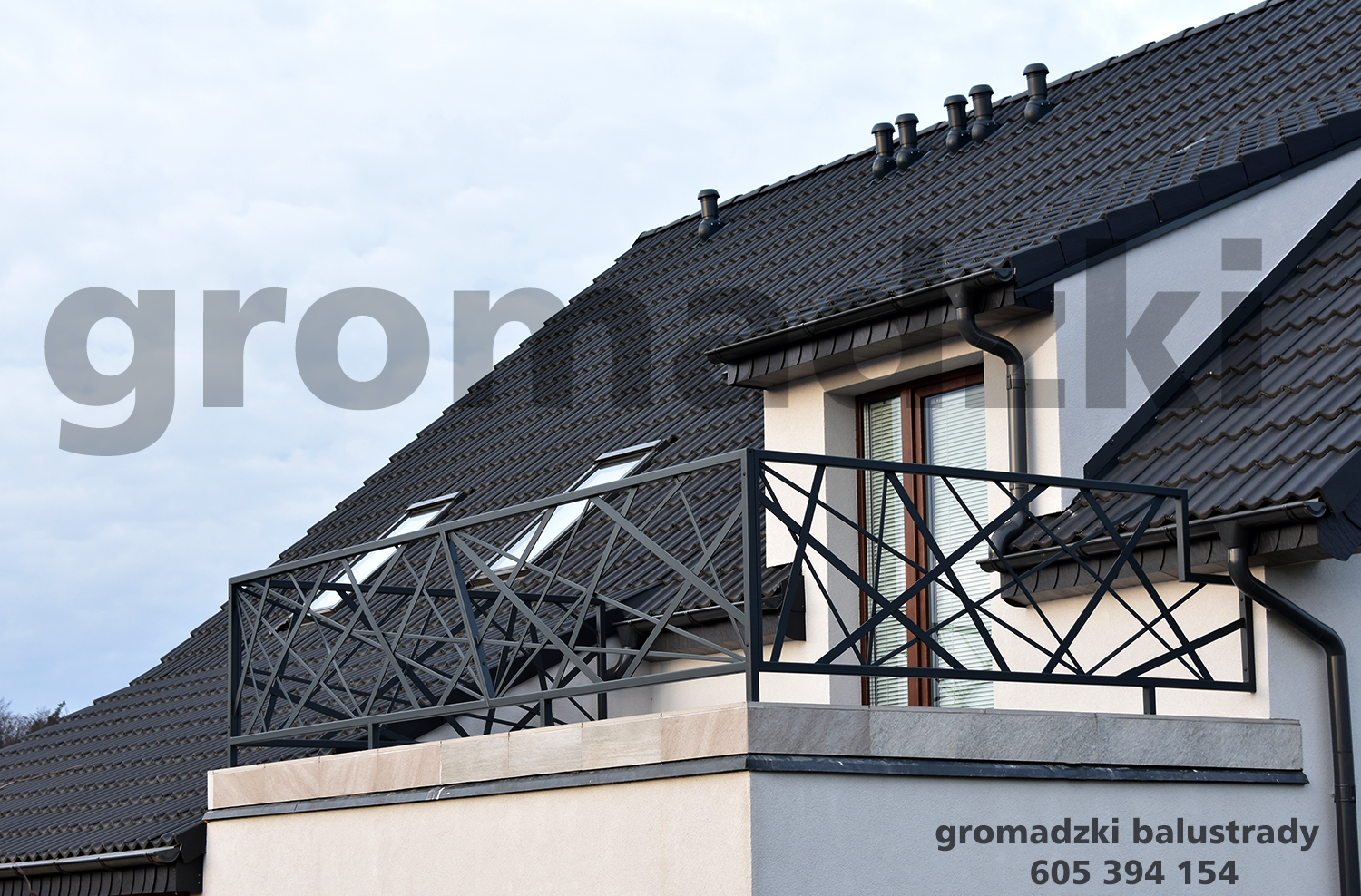 Czarna, geometryczna balustrada balkonowa z metalu na tle dachu z dachówki i okna z żaluzjami.