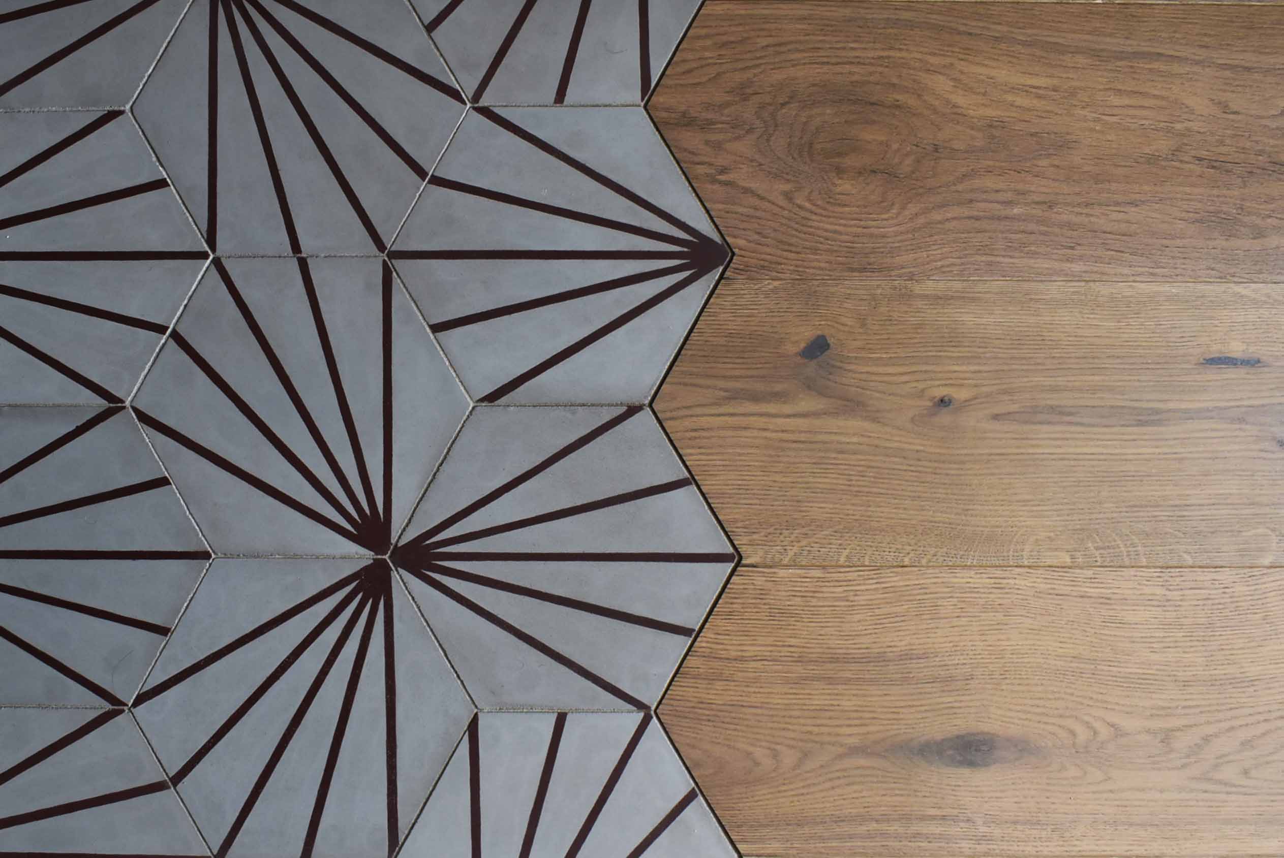 Połączenie podłogi drewnianej i heksagonalnych płytek z geometrycznym wzorem brązowych linii.