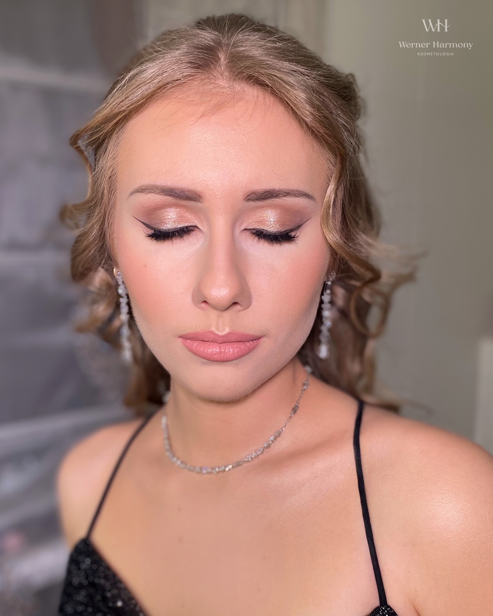 Portret młodej kobiety z zamkniętymi oczami, prezentującej delikatny, profesjonalny  z brokatem i czarną kreską, srebrna biżuteria.