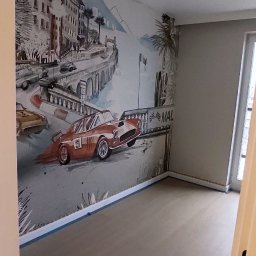RENOVA - Pokój po malowaniu z fototapetą przedstawiającą wyścigowe samochody i krajobraz miejski. Podłoga wykończona panelami. Widoczne taśmy malarskie przy podłodze.