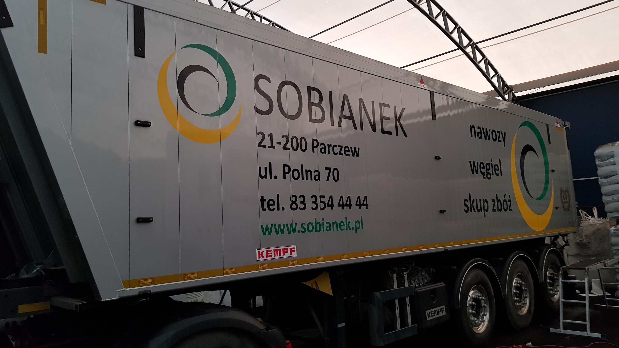 Ciężarówka z naczepą firmy Sobianek z Parczewa, oferującej nawozy, węgiel i skup zbóż, z widocznym logo i danymi kontaktowymi.