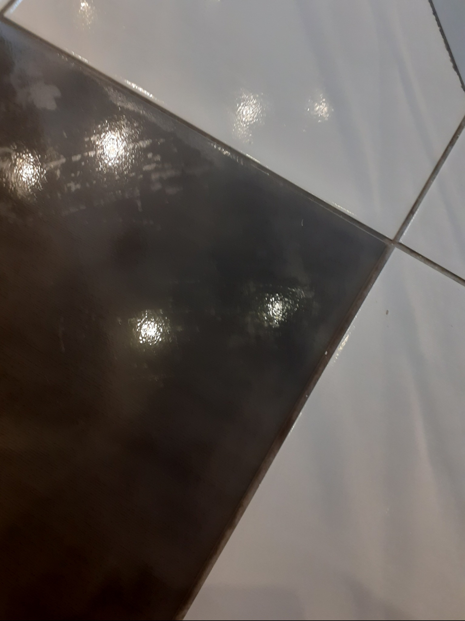 Błyszczące, czarno-białe płytki podłogowe po sprzątaniu w układzie szachownicy, widoczne fugi w Sucha Beskidzka. Czystość i połysk.