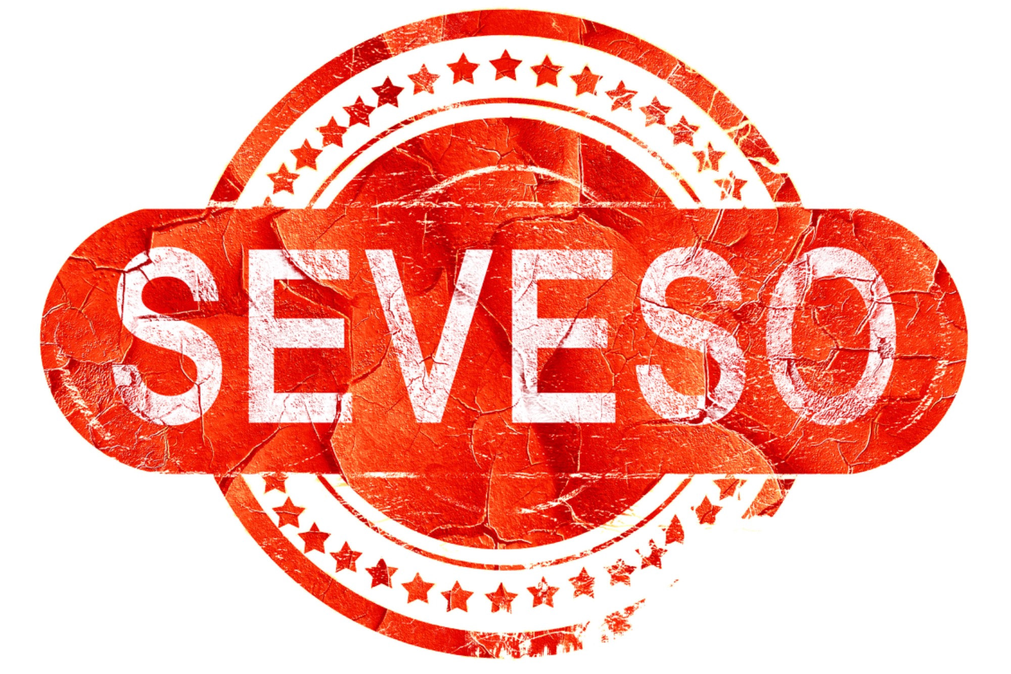 Czerwona, okrągła pieczęć z białym napisem SEVESO i gwiazdami, o teksturze popękanej farby.