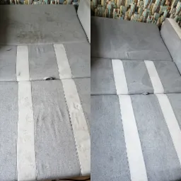 Szara kanapa w paski, widok przed i po czyszczeniu, po lewej stronie widoczne zabrudzenia, po prawej czysta powierzchnia, na tle tapeta w motywy miejskie.