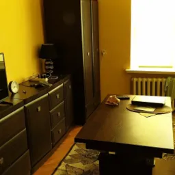 Pokój z żółtymi ścianami, ciemnymi meblami, rozłożonym stołem z laptopem i wzorzystym dywanem.