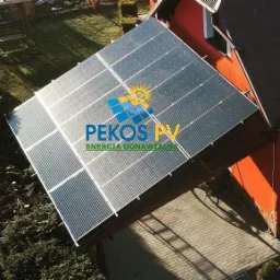 Instalacja fotowoltaiczna na dachu domu, widok z góry, logo firmy PEKOS PV widoczne na panelach.