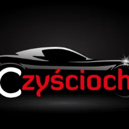 Eleganckie logo firmy 'Czyścioch' przedstawiające sylwetkę sportowego samochodu w czerni i szarości z błyszczącym reflektorem na czarnym tle.