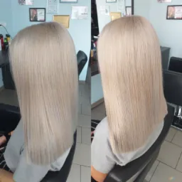 Dwa ujęcia z tyłu przedstawiające proste, platynowe blond włosy do ramion, wykonane w salonie; widoczne dyplomy i kosmetyki w tle.