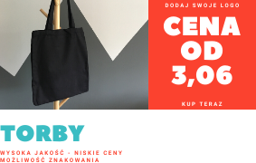 Czarna torba bawełniana na drewnianym wieszaku, na tle szaro-białej ściany z geometrycznym wzorem, obok czerwona reklama z ceną i napisem 'Torby'.