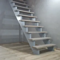 Proste, metalowe schody wewnętrzne w odcieniach szarości, z drewnopodobnymi stopniami, na tle szarej ściany o fakturze betonu i jasnej podłogi laminowanej.