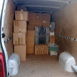 MoveTransport - Wnętrze furgonetki wypełnione kartonami i przedmiotami, gotowe do transportu z Goszczyna. Widoczne zabezpieczenia z folii bąbelkowej.