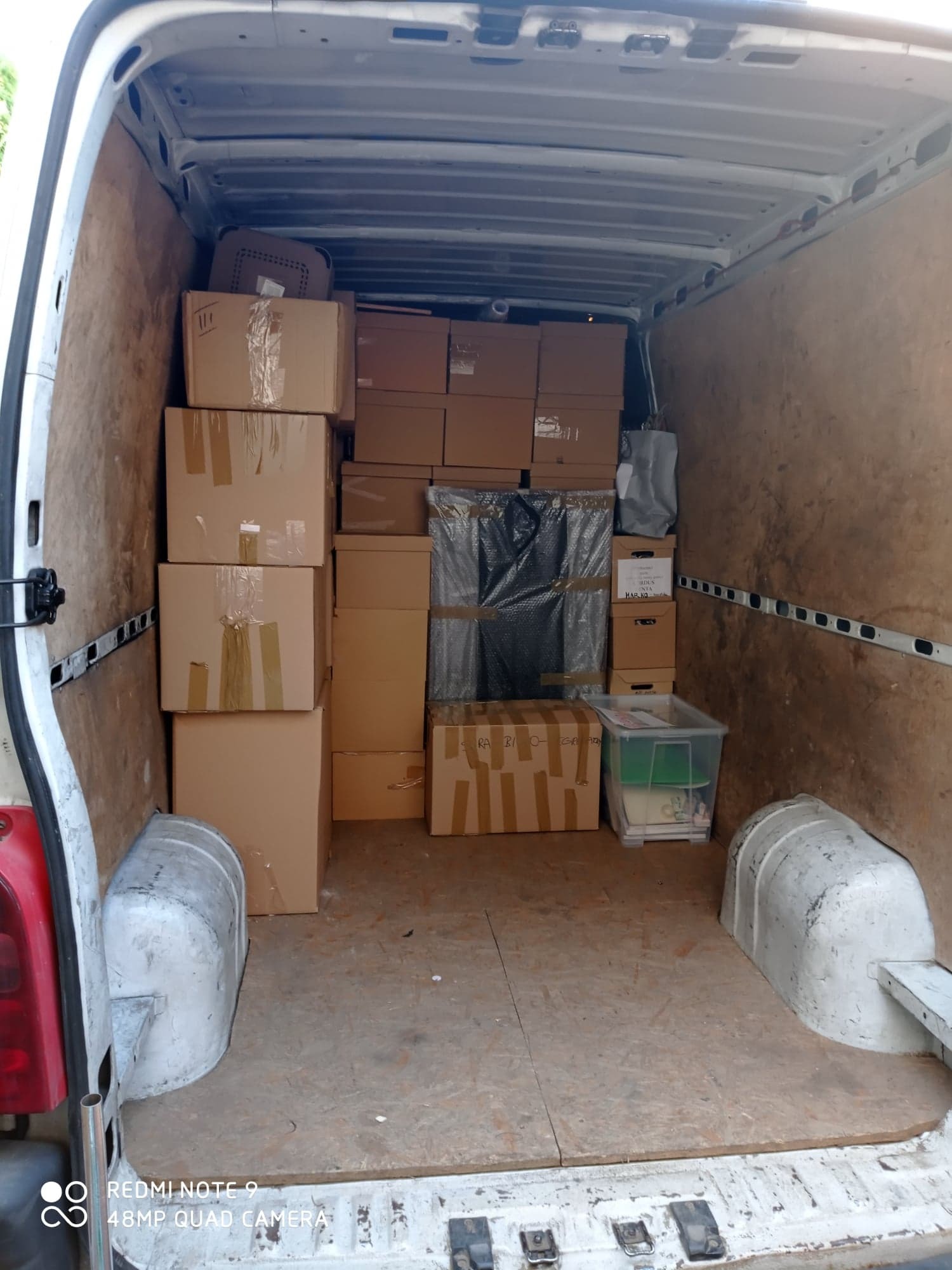 Wnętrze furgonetki wypełnione kartonami i przedmiotami, gotowe do transportu z Goszczyna. Widoczne zabezpieczenia z folii bąbelkowej.