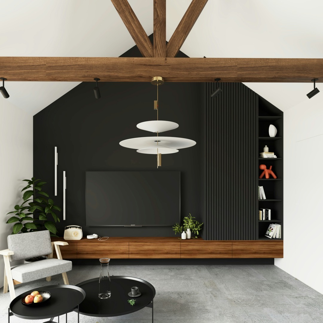 Jasne, przestronne wnętrze salonu z wysokim sufitem i drewnianymi belkami, czarną ścianą z telewizorem i drewnianą szafką RTV, szarym fotelem i stolikami kawowymi na betonowej podłodze.