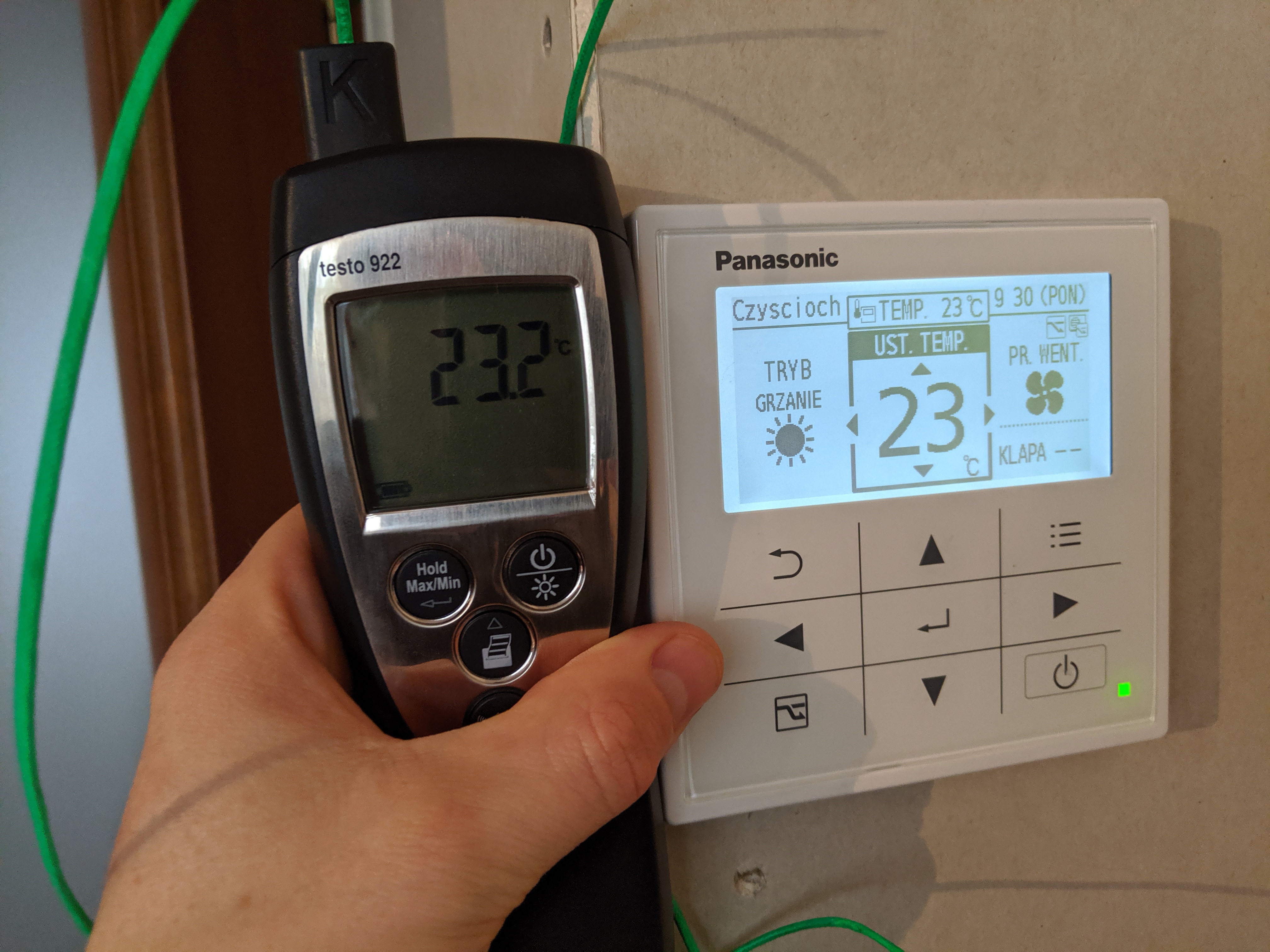 Pomiar temperatury nawiewu klimatyzacji za pomocą termometru elektronicznego Testo 922, obok widoczny panel sterowania Panasonic z wyświetlaczem ustawień.