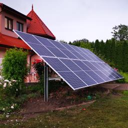 ARCHIGON Sp. z o.o. - Instalacja paneli słonecznych w Tarnowie na tle różowego domu z czerwoną dachówką, otoczona zielenią.