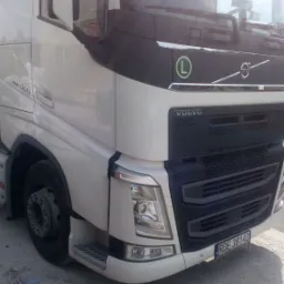 Przód białej ciężarówki Volvo z widoczną tablicą rejestracyjną RDE 38142 na tle szarej nawierzchni.