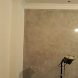 Ściana w pokoju po dekoracyjnym malowaniu z widocznym reflektorem oświetlającym efekt, widoczna listwa przysufitowa.