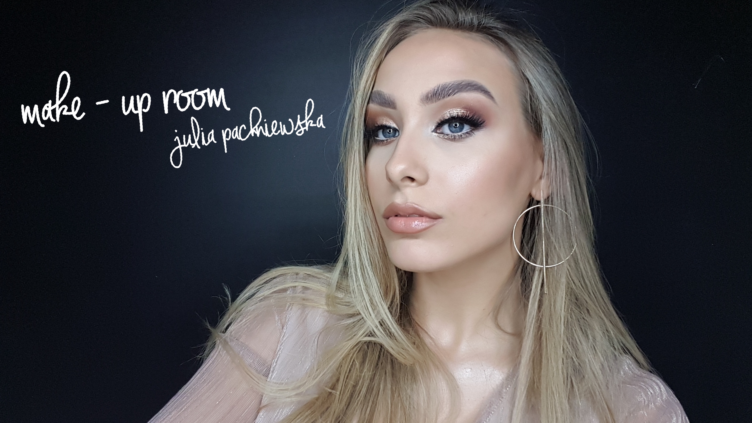 Portret kobiety z profesjonalnym makijażem oczu w odcieniach brązu i złota, błyszczące usta, blond włosy i kolczyk koło na tle czarnej ściany z napisem 'make-up room julia pachniewska'.